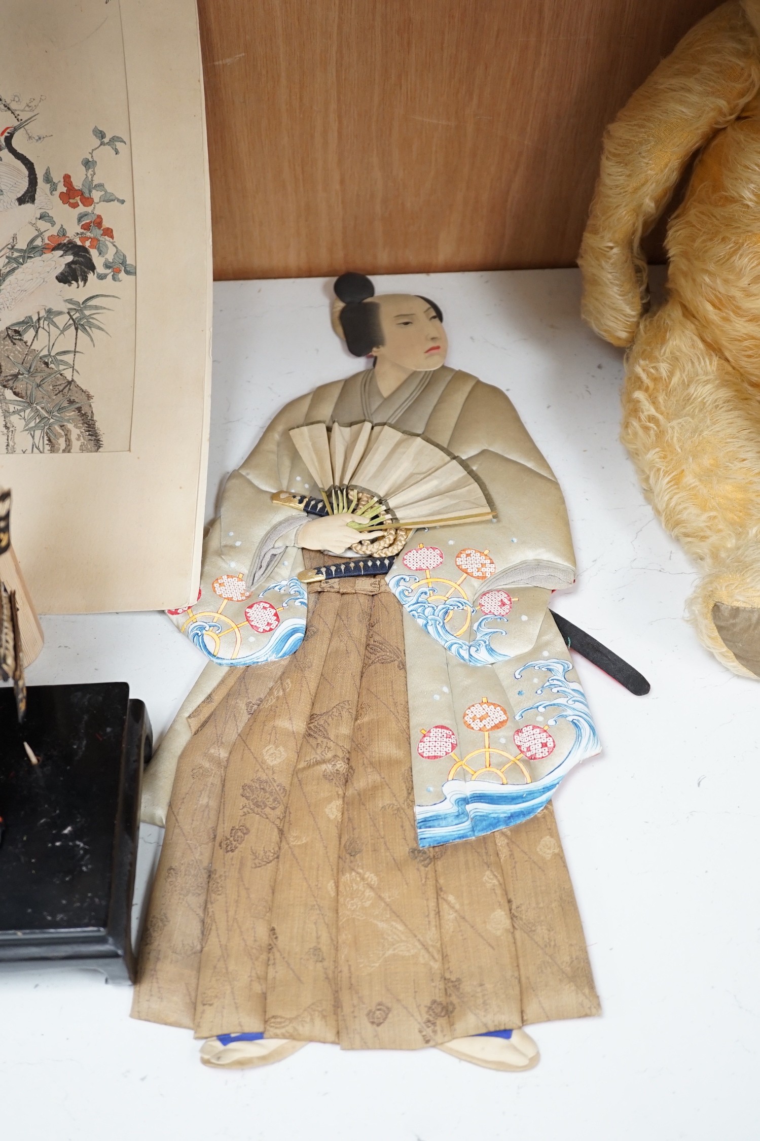 A Japanese seated Samurai figure on stand, two appliquéd fabric figures and a Chinese print, tallest figure 48cms high